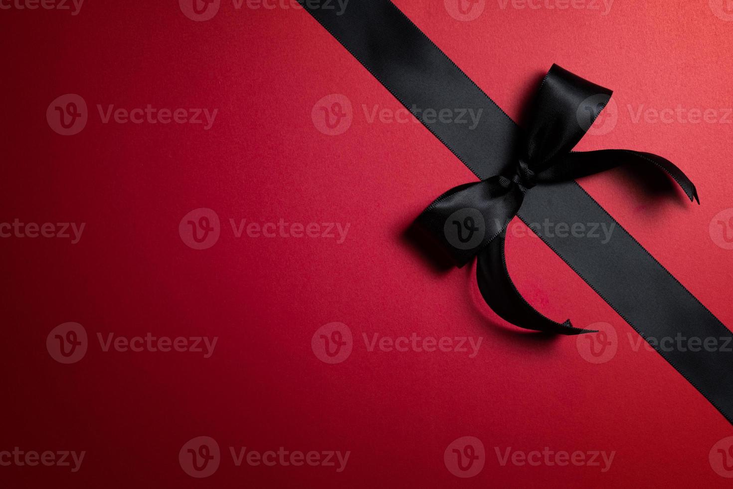 Top view of black ribbon on red background with free copy space for text. photo