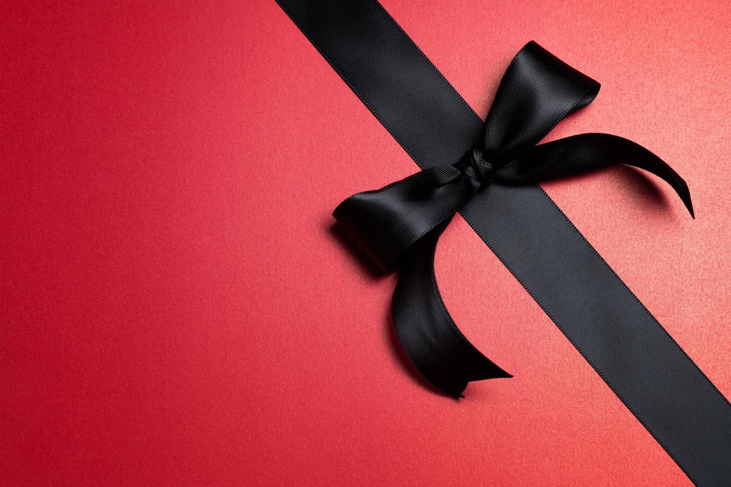 Top view of black ribbon on red background with free copy space for text. photo