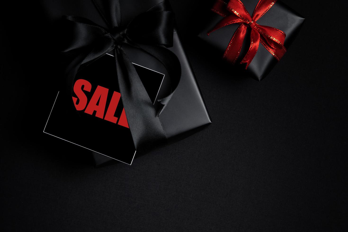 Top view of Black Friday Sale text with black gift box isolated on black background. photo