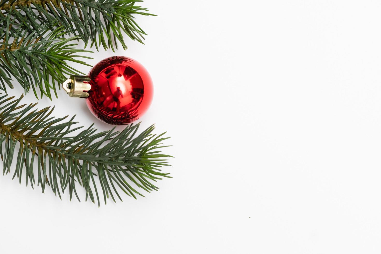 Top view of Christmas gift box red balls with spruce branches, pine cones, red berries and bell on white background. photo