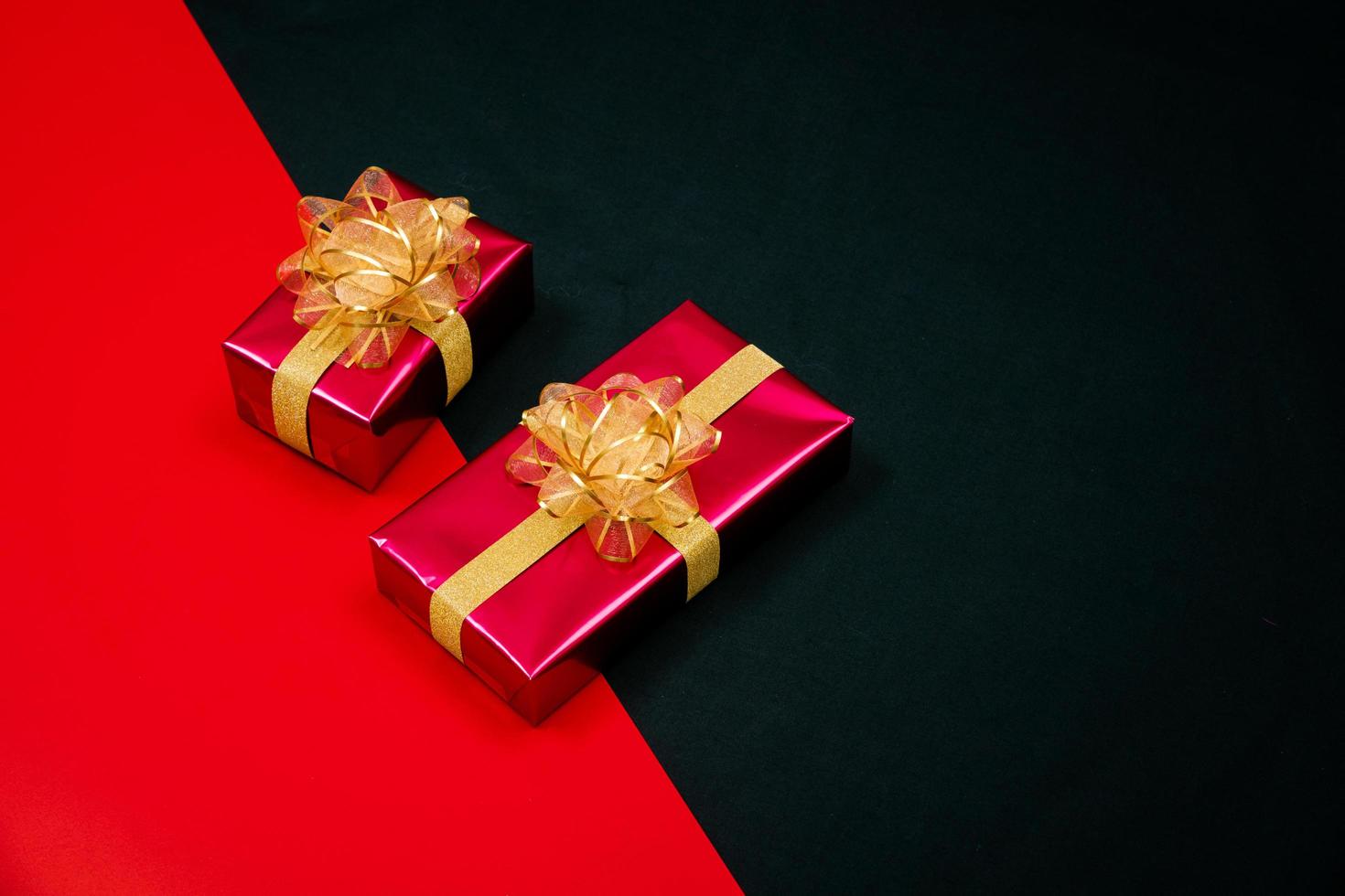 black gift box with black ribbons isolated on black background photo