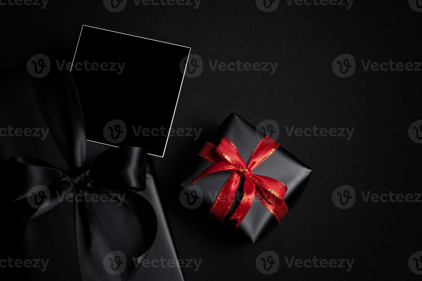 Top view of free space for text with black gift box isolated on black background. photo