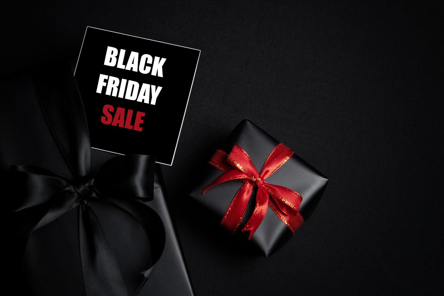 Top view of Black Friday Sale text with black gift box isolated on black background. photo