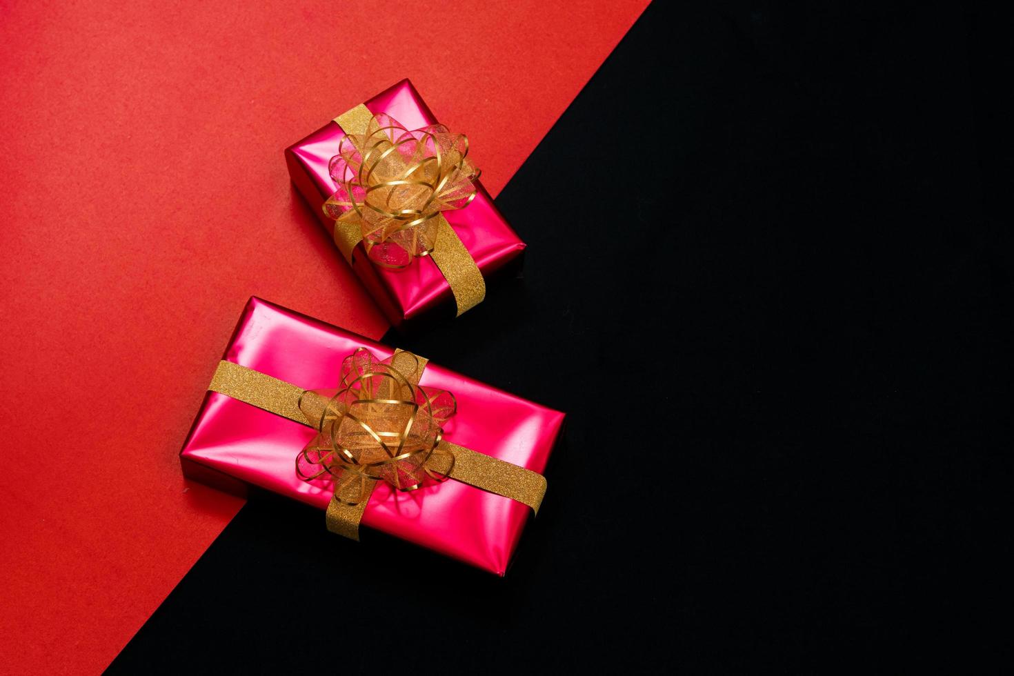 black gift box with black ribbons isolated on black background photo