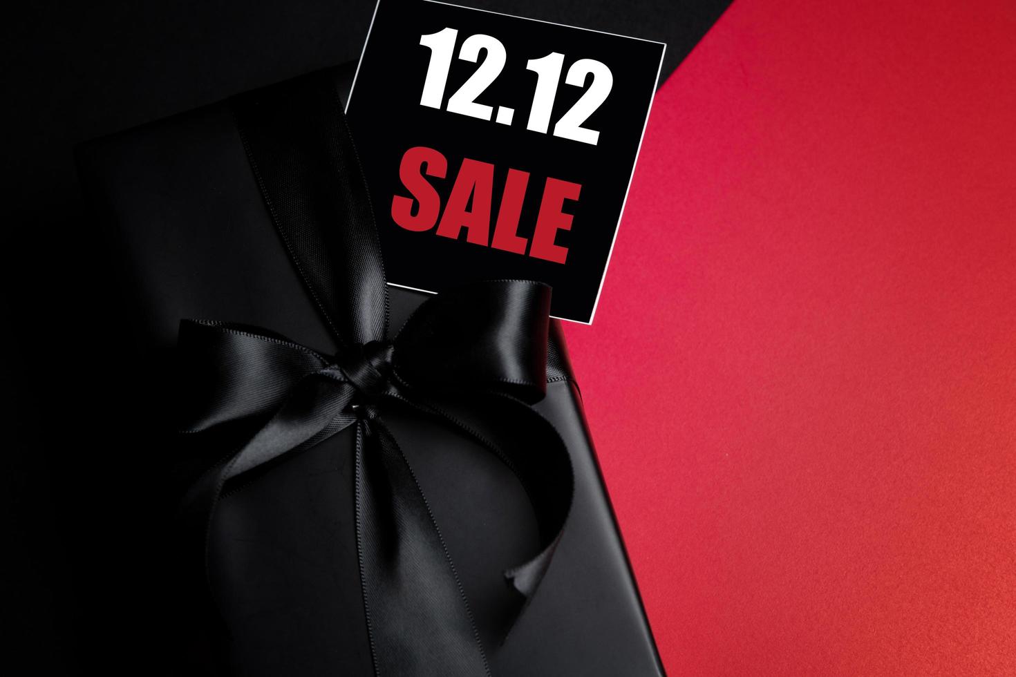 vista superior de la caja de regalo negra con fondo negro con espacio de copia para texto 12.12 venta de día de solteros. foto