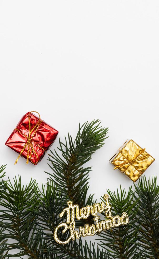 Top view of Christmas gift box red balls with spruce branches, pine cones, red berries and bell on white background. photo