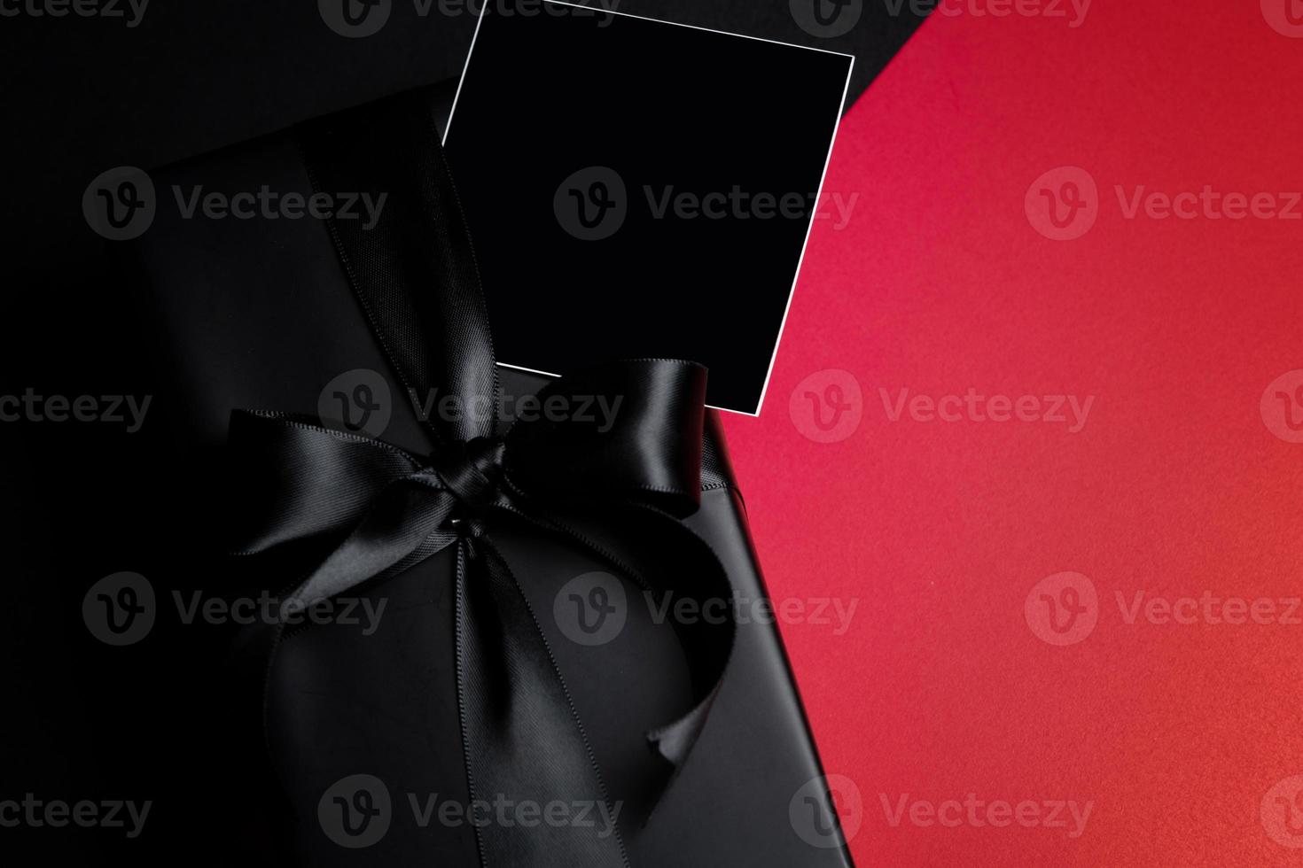 Top view of free space for text with black gift box isolated on black background. photo