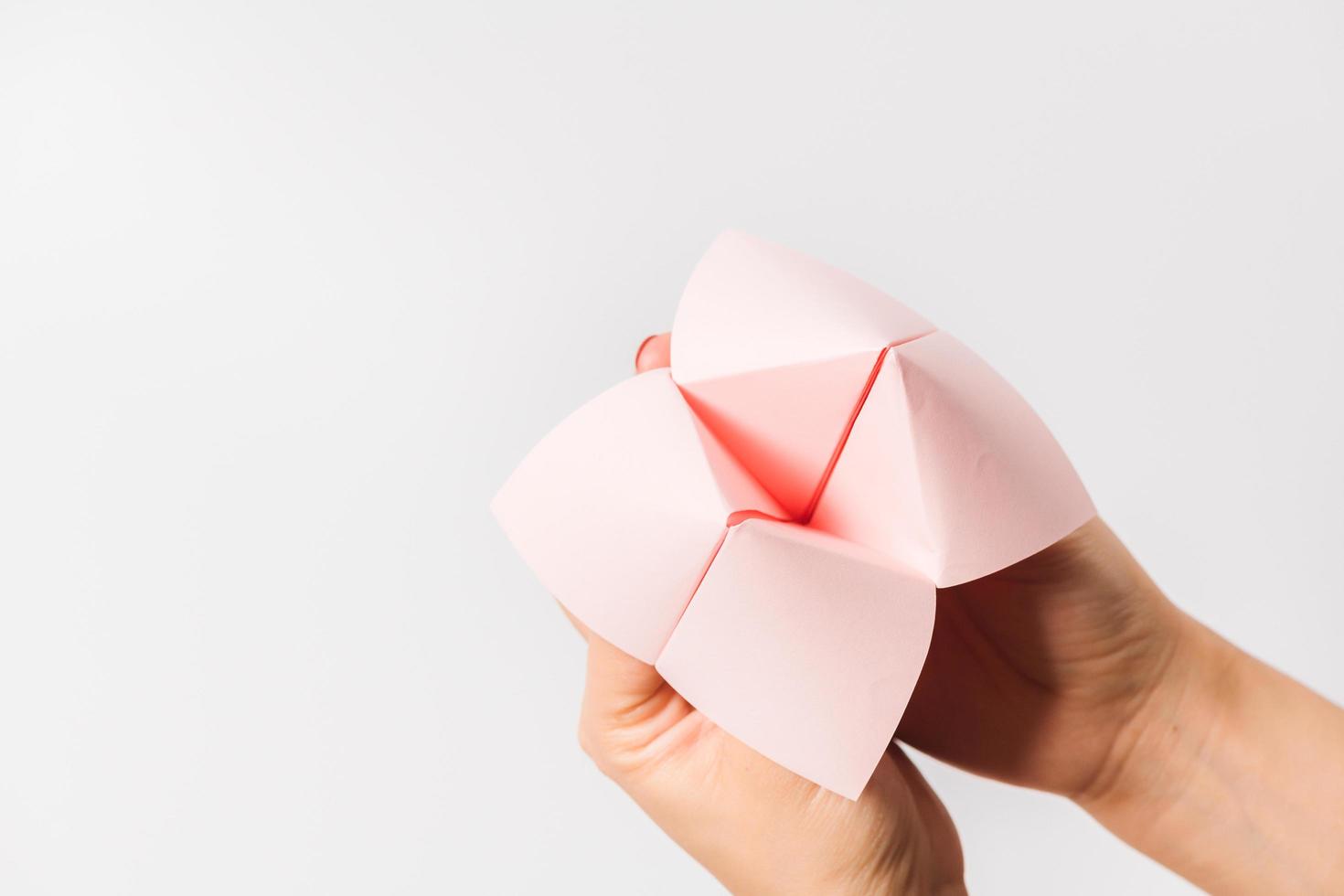 Hand in a paper fortune teller isolated on white background. photo