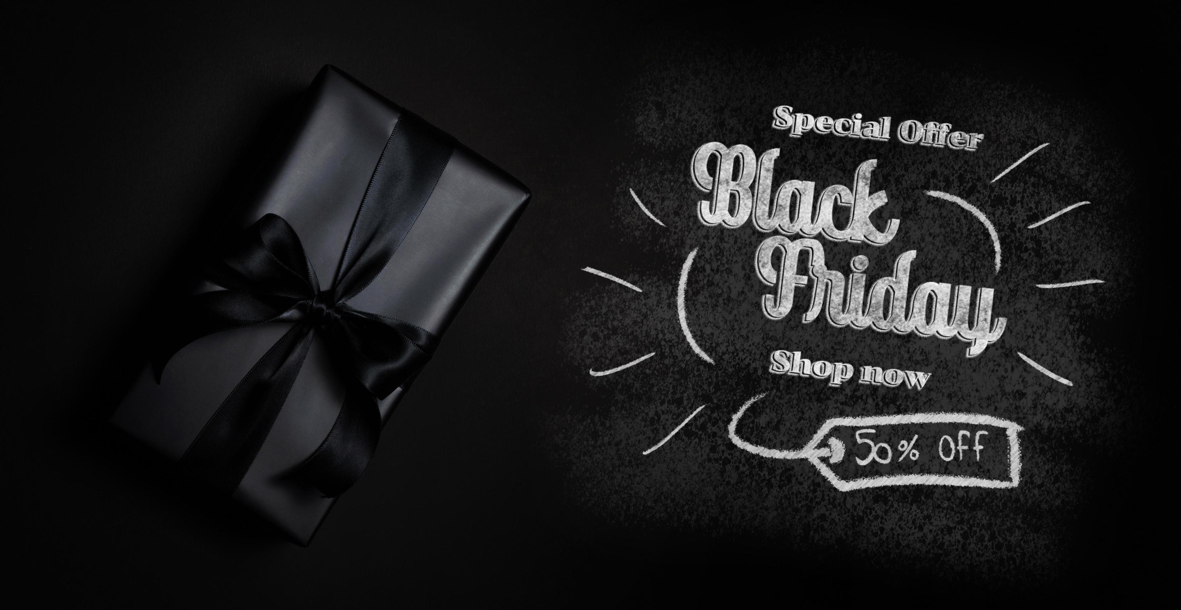 Top view of black gift box with black ribbons isolated on black