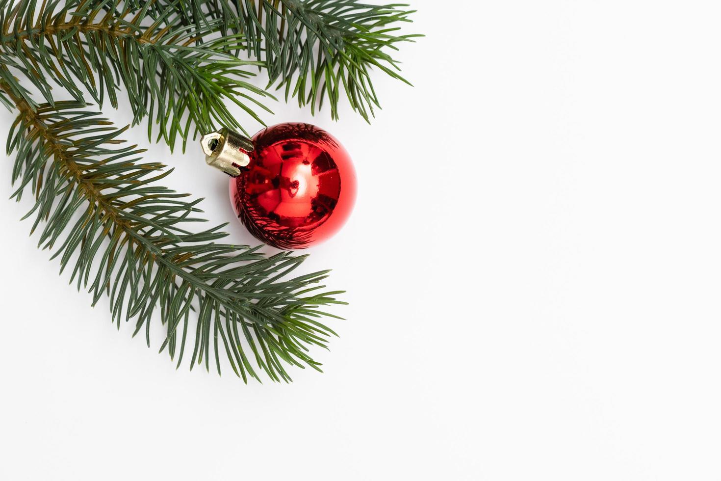 Top view of Christmas gift box red balls with spruce branches, pine cones, red berries and bell on white background. photo