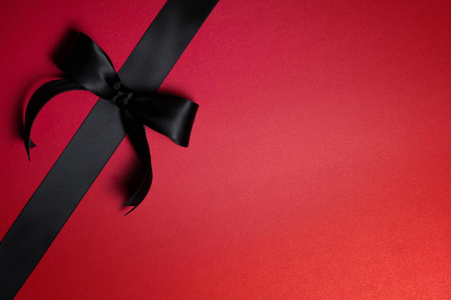 Top view of black ribbon on red background with free copy space for text. photo