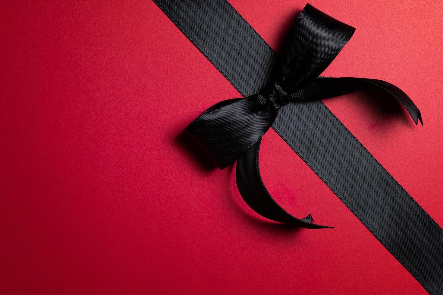 Top view of black ribbon on red background with free copy space for text. photo