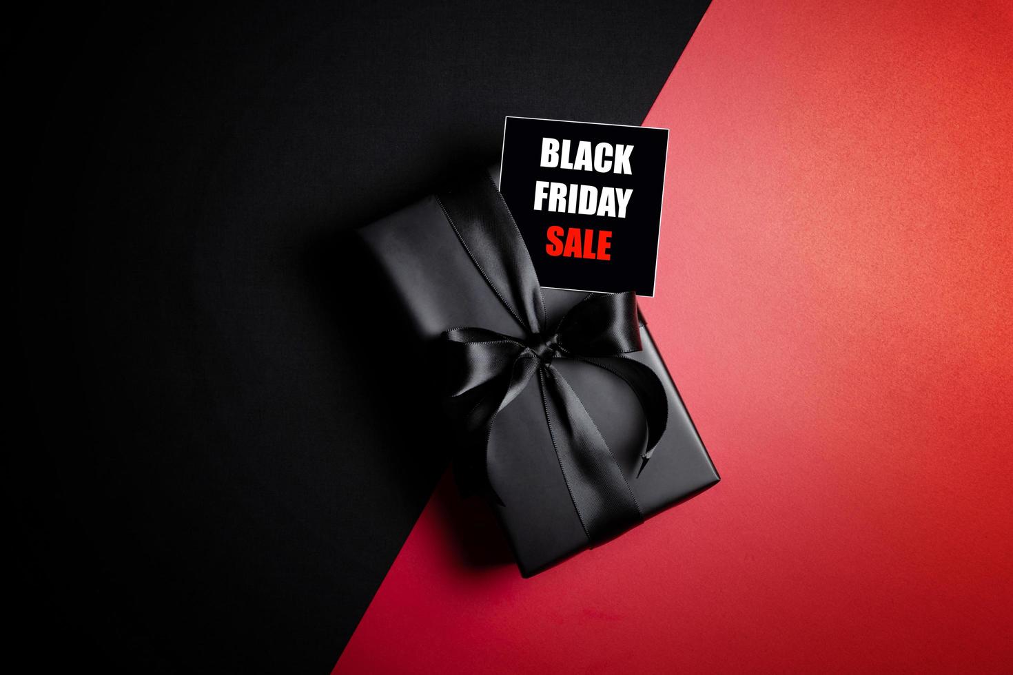 Top view of Black Friday Sale text with black gift box isolated on black background. photo