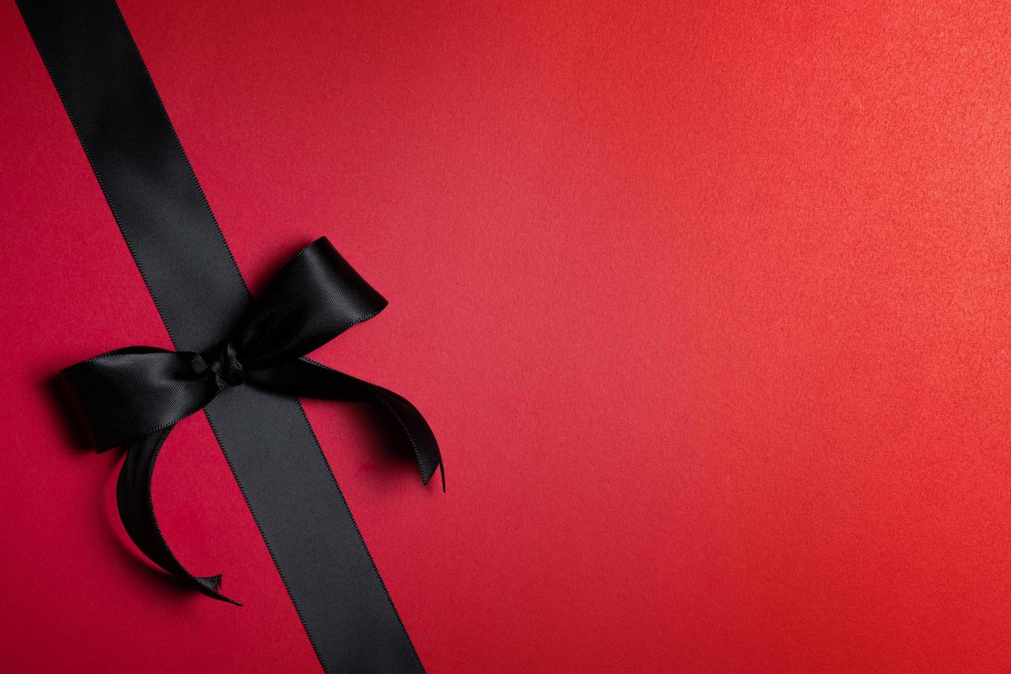 Top view of black ribbon on red background with free copy space for text. photo