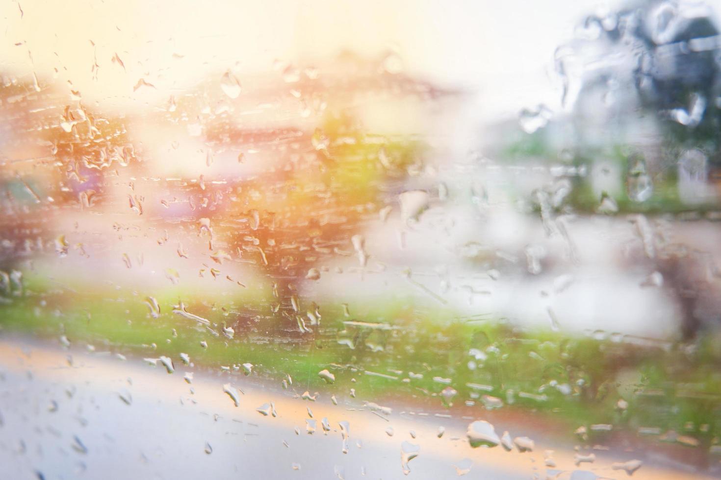 Rain drops on glass Rainy day window glass with water drops and nature blur background photo