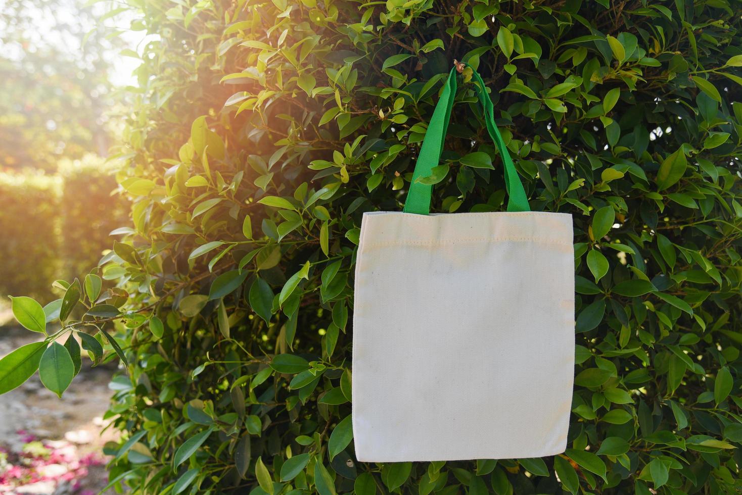 Tote blanco tela de lona bolsa ecológica saco de compras de tela sobre fondo de naturaleza de hoja verde foto