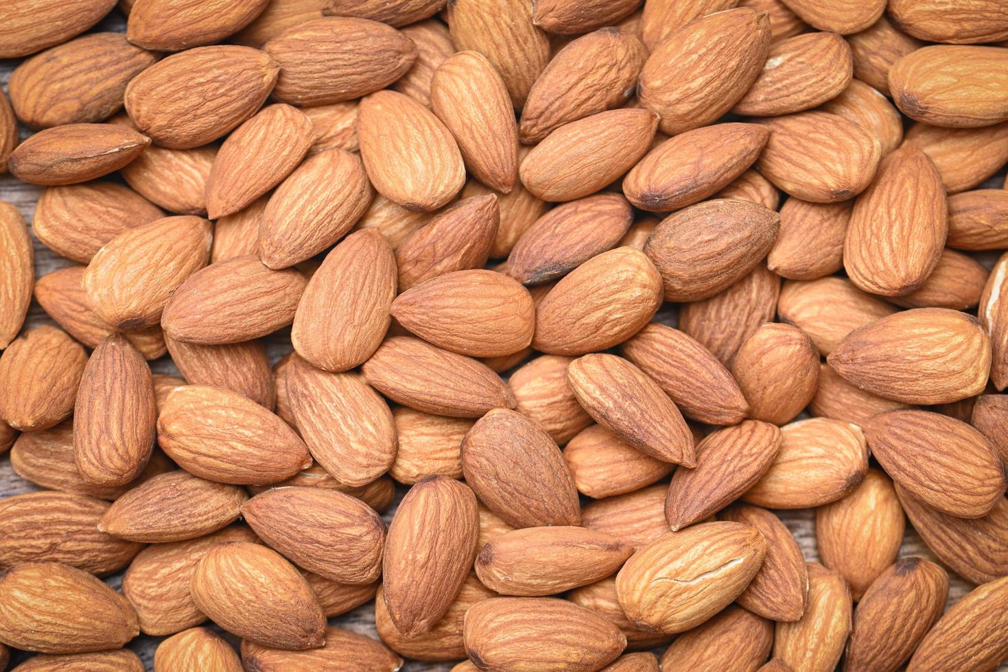 Top view almonds nuts on background, Close up delicious sweet almonds, roasted almond nut for healthy food and snack photo