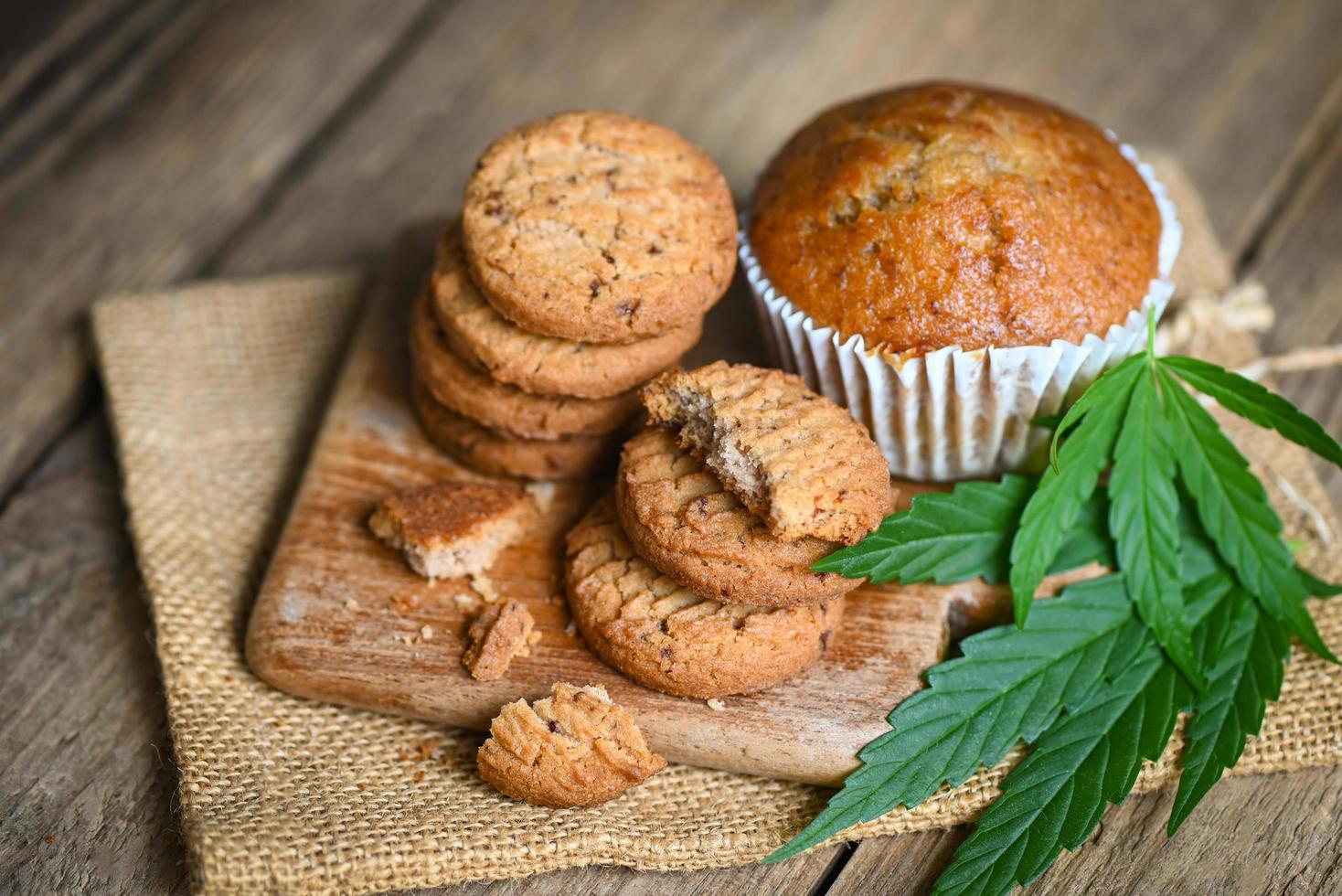 Cannabis food cookies with cake chocolate cannabis leaf marijuana herb on wooden and dark background, delicious sweet dessert cookie with hemp leaf plant THC CBD herbs food snack and medical photo