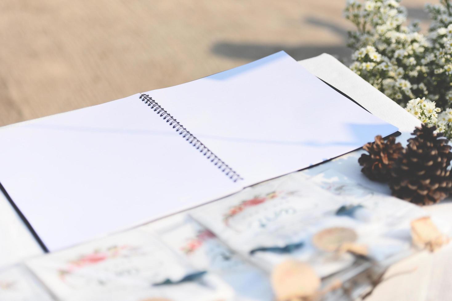 Notebook on table outdoors Blank white paper photo