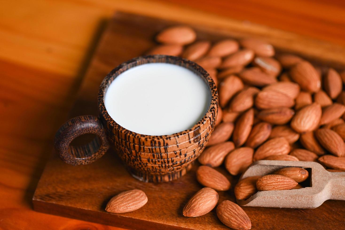 Almond milk and Almonds nuts on wooden background, Delicious sweet almonds on the table, roasted almond nut for healthy food and snack photo