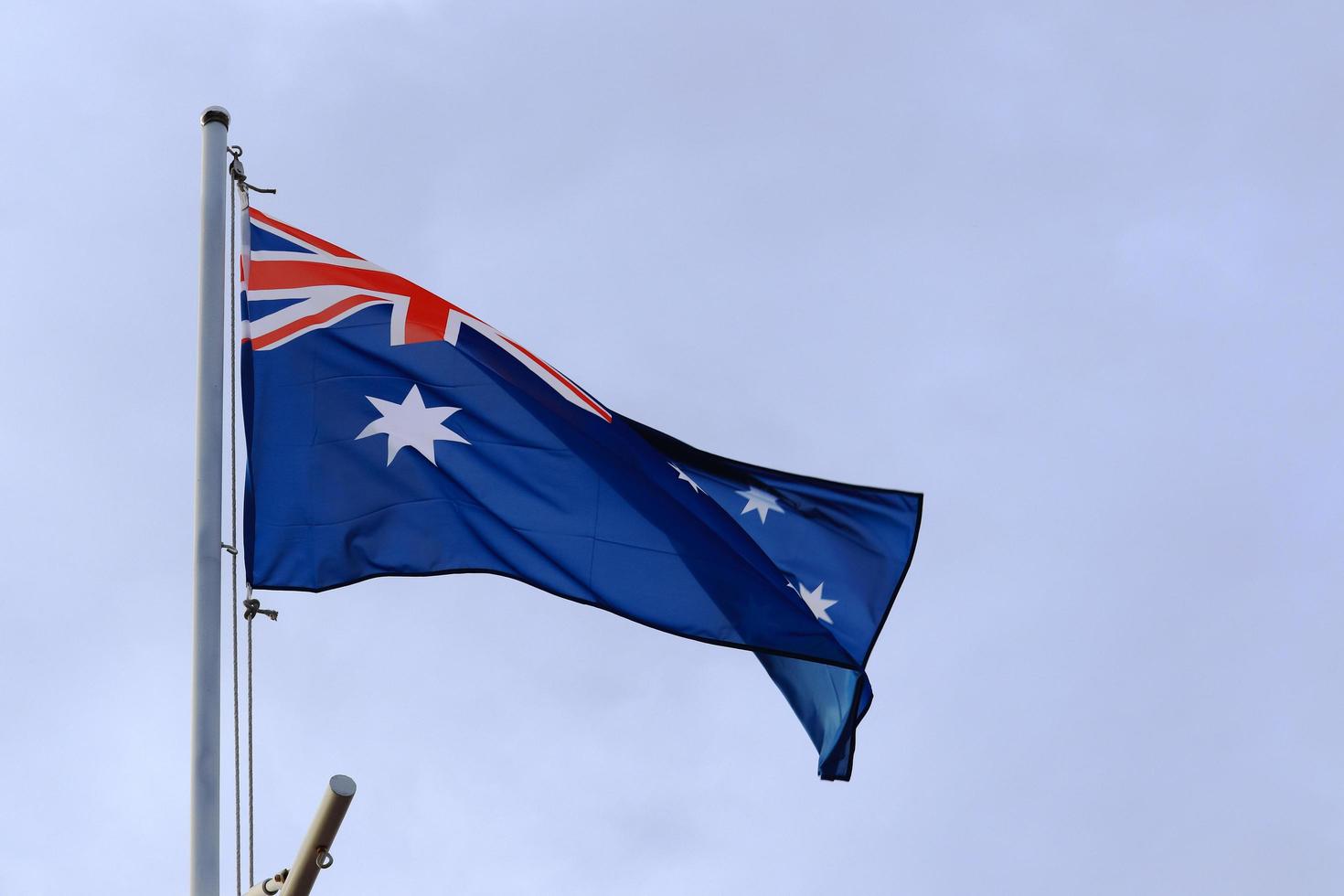 Australian flag fluttering on the flagpole photo