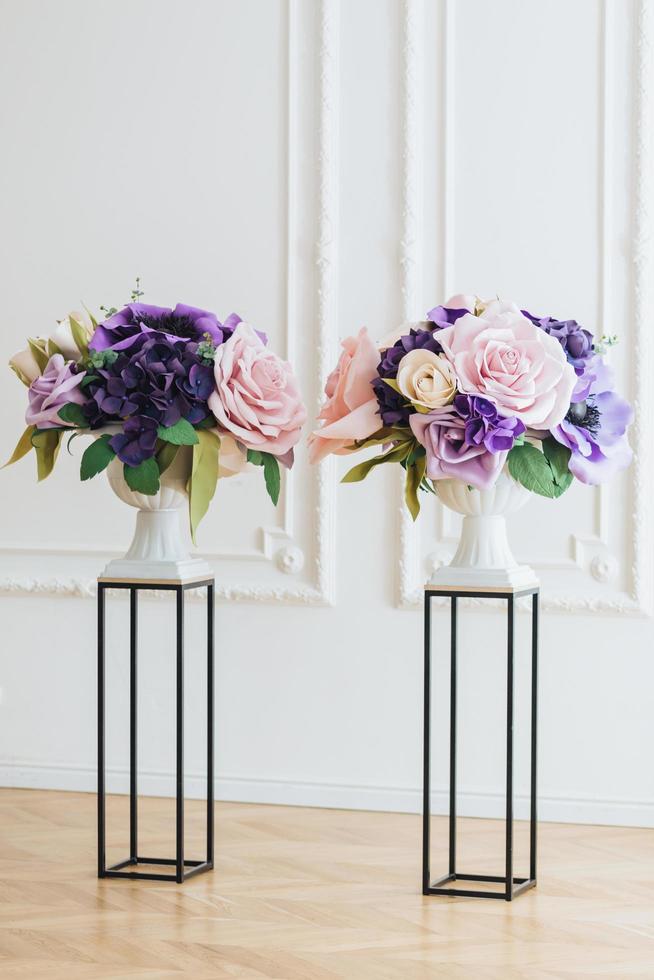 decoración para la ceremonia de la boda. flores naturales en jarrones blancos sobre soporte aislado sobre fondo blanco. tiro interior vertical. rosas hermosas. foto