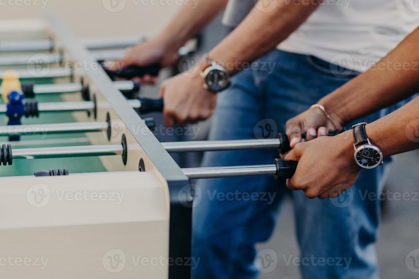 People enjoy playing soccer game, play table football, enjoy recreation time. Mini game. Leisure and activities concept. Entertainment concept photo