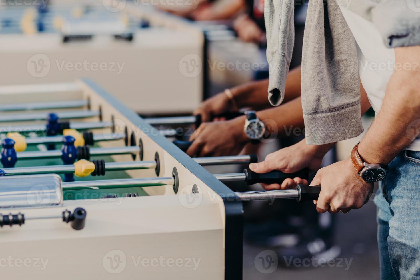 People, lifestyle, gambling and recreation concept. Active male player enjoy spare time while play table football together. People have kicker match photo