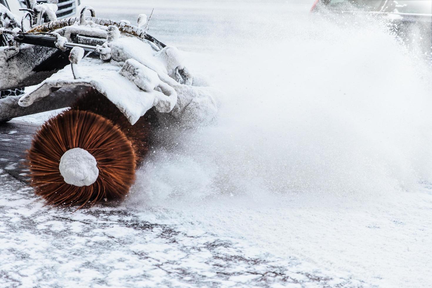 Snow blowing machine works outdoor after heavy snowstrom. Excavator on winter day. Tractor removes snow from road. Winter problems and weather conditions concept photo