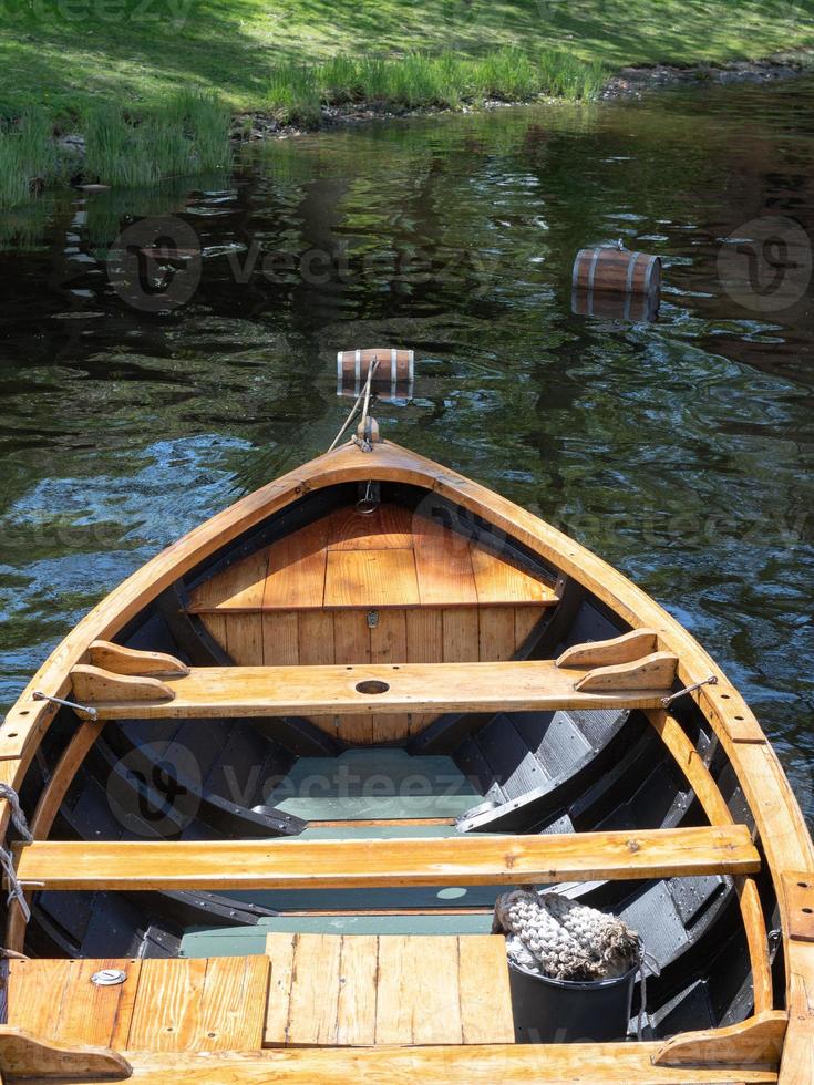 A wooden rowboat seen from above as it bobs on the water. photo