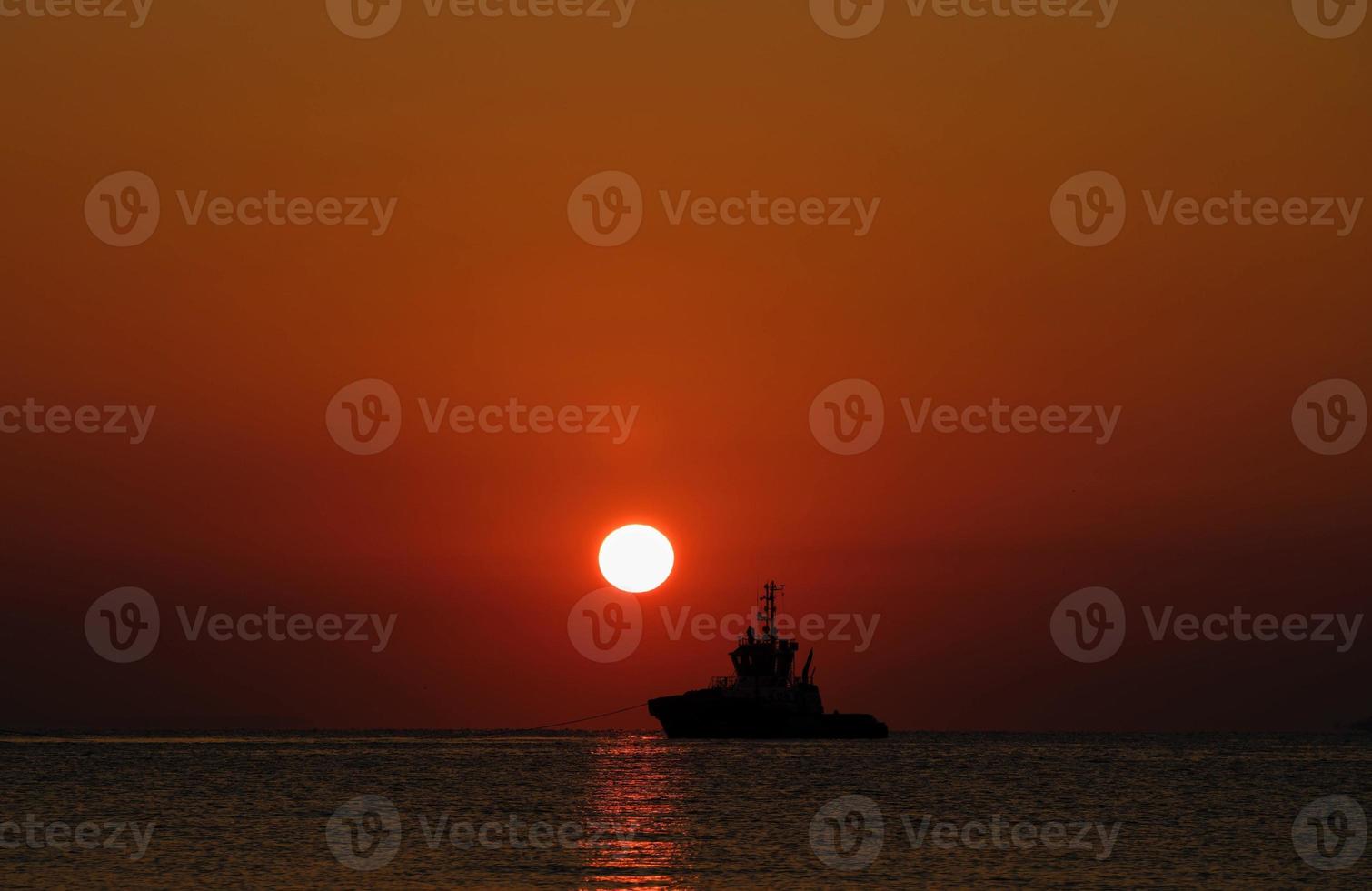 A ship leaving port at sunrise photo