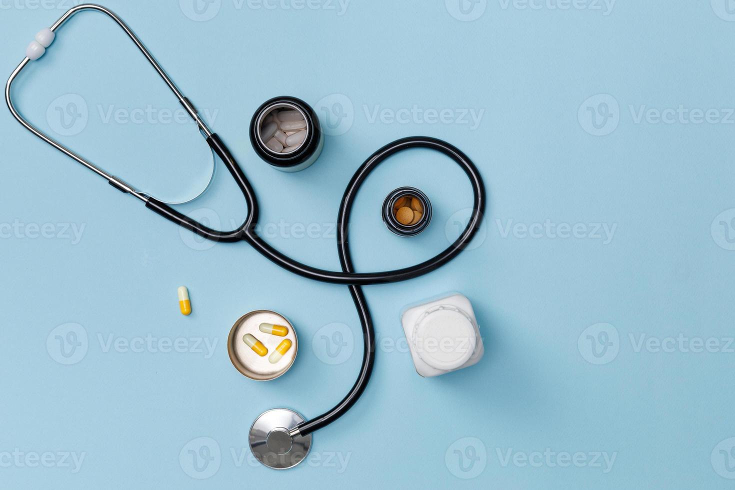 Creative flatlay of doctor medical equipment blue table with stethoscope, medical documents, thermometer, syringe and pills, Health care concept, Top view with copy space for your text photo