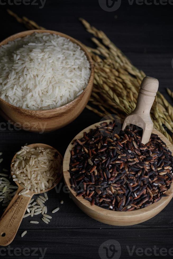 arroz blanco y semillas de arroz paddy sobre mesa de madera, arroz jazmín orgánico foto