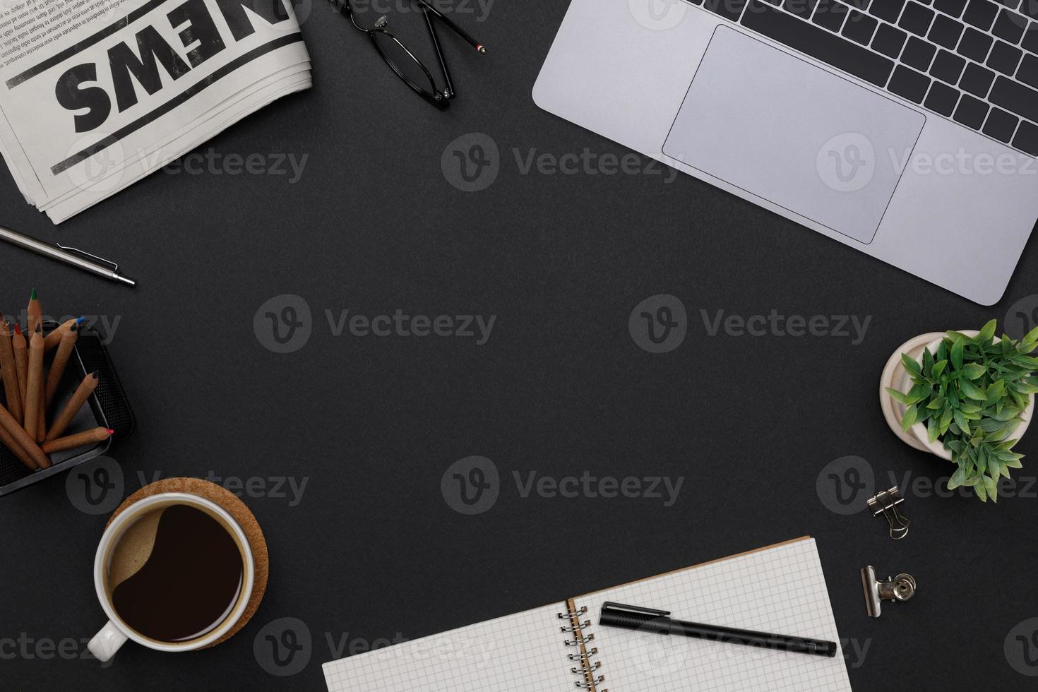 Creative flatlay of office supplies mockup with notebook, hot coffee cup, glasses, books, newspaper and accessories on black desk topview with copy space, Workspace for freelancer background photo