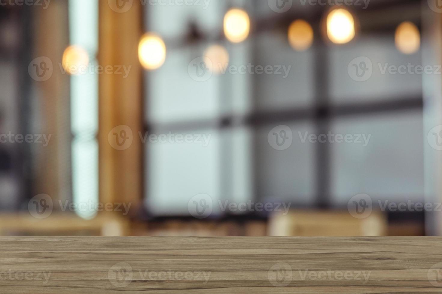 Empty wooden table top with view of room or wooden desk with restaurants with blur background, copy space for your text photo