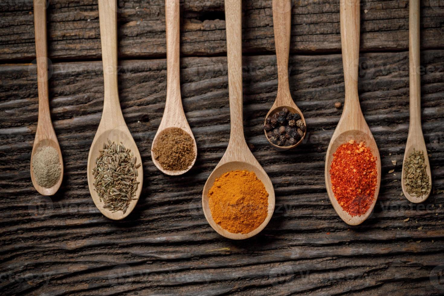 Herbs and spices and the spoon on the wooden table photo