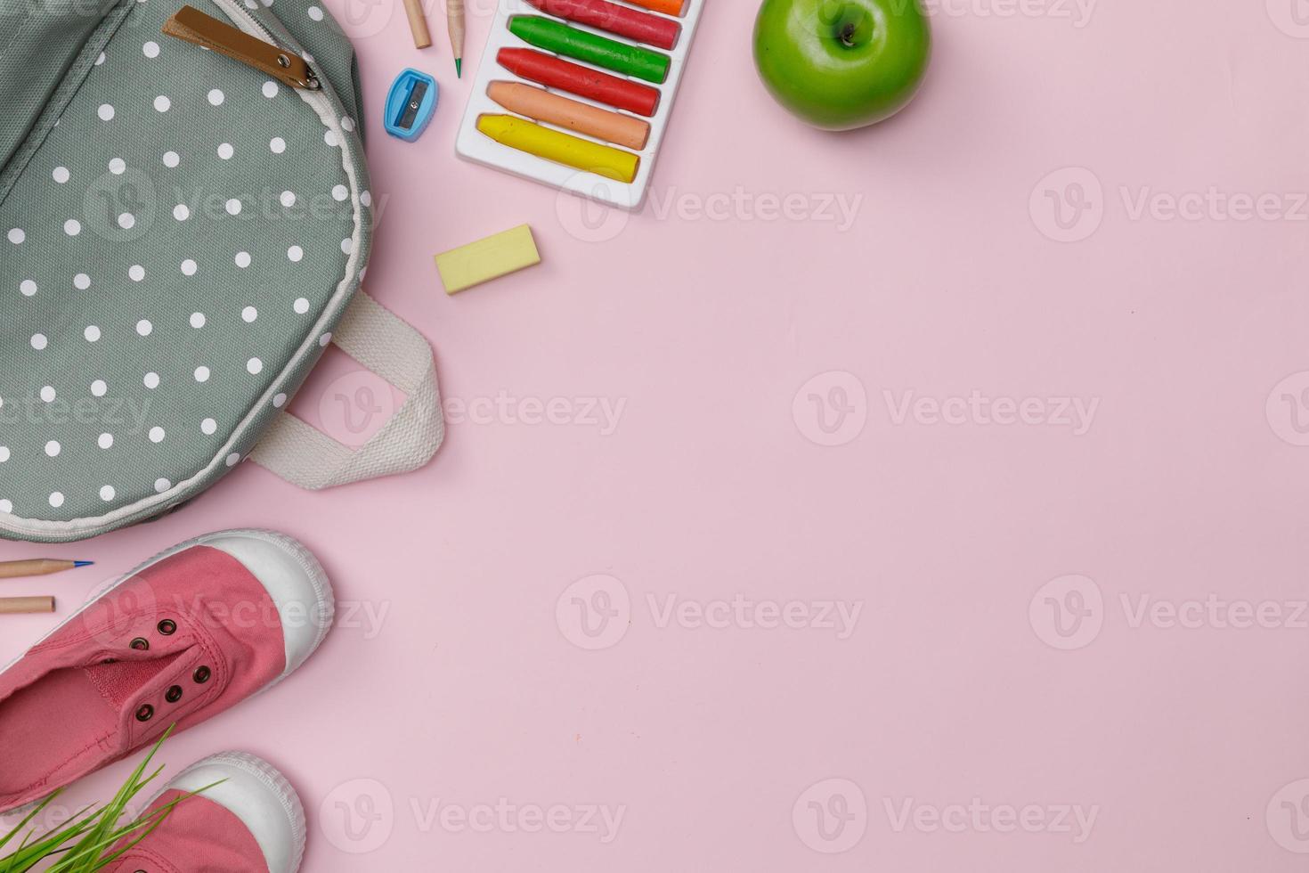 Creative flatlay of education pink table with backpack, student books, shoes, colorful crayon, empty space isolated on pink background, Concept of education and back to school photo