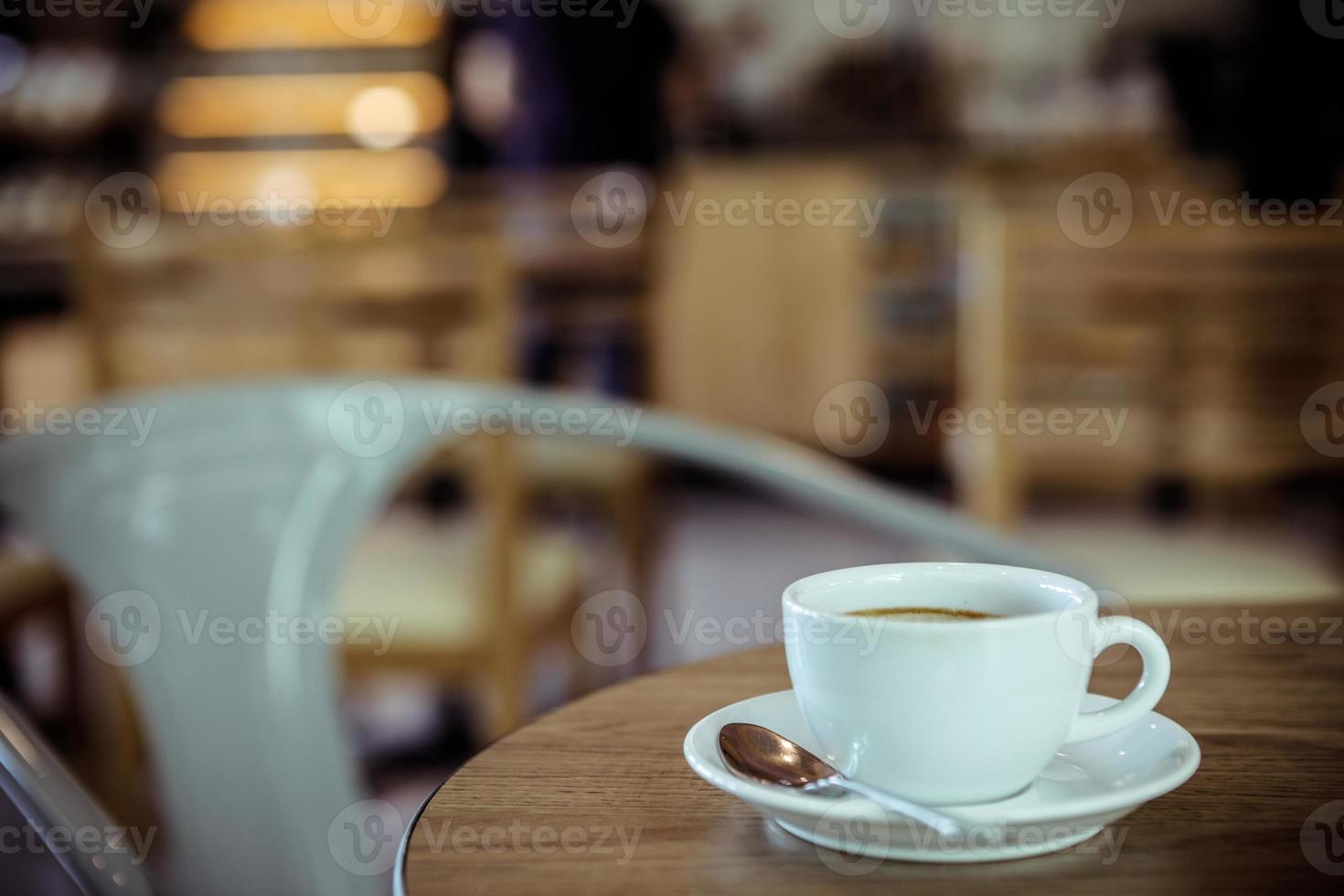 Cup of coffee on table in cafe - vintage style effect picture photo