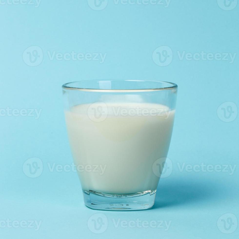 vaso de leche sobre fondo azul. foto