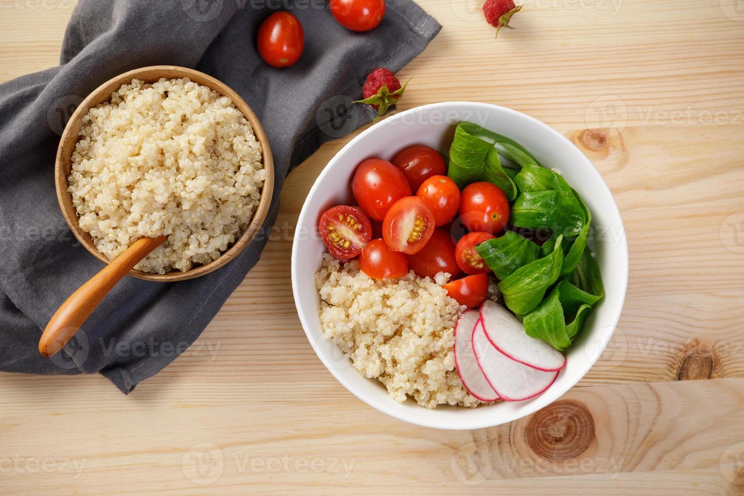 ensalada de quinua con verduras, frambuesa y tomates en la mesa de madera. súper alimento para la salud y el concepto de dieta equilibrada foto
