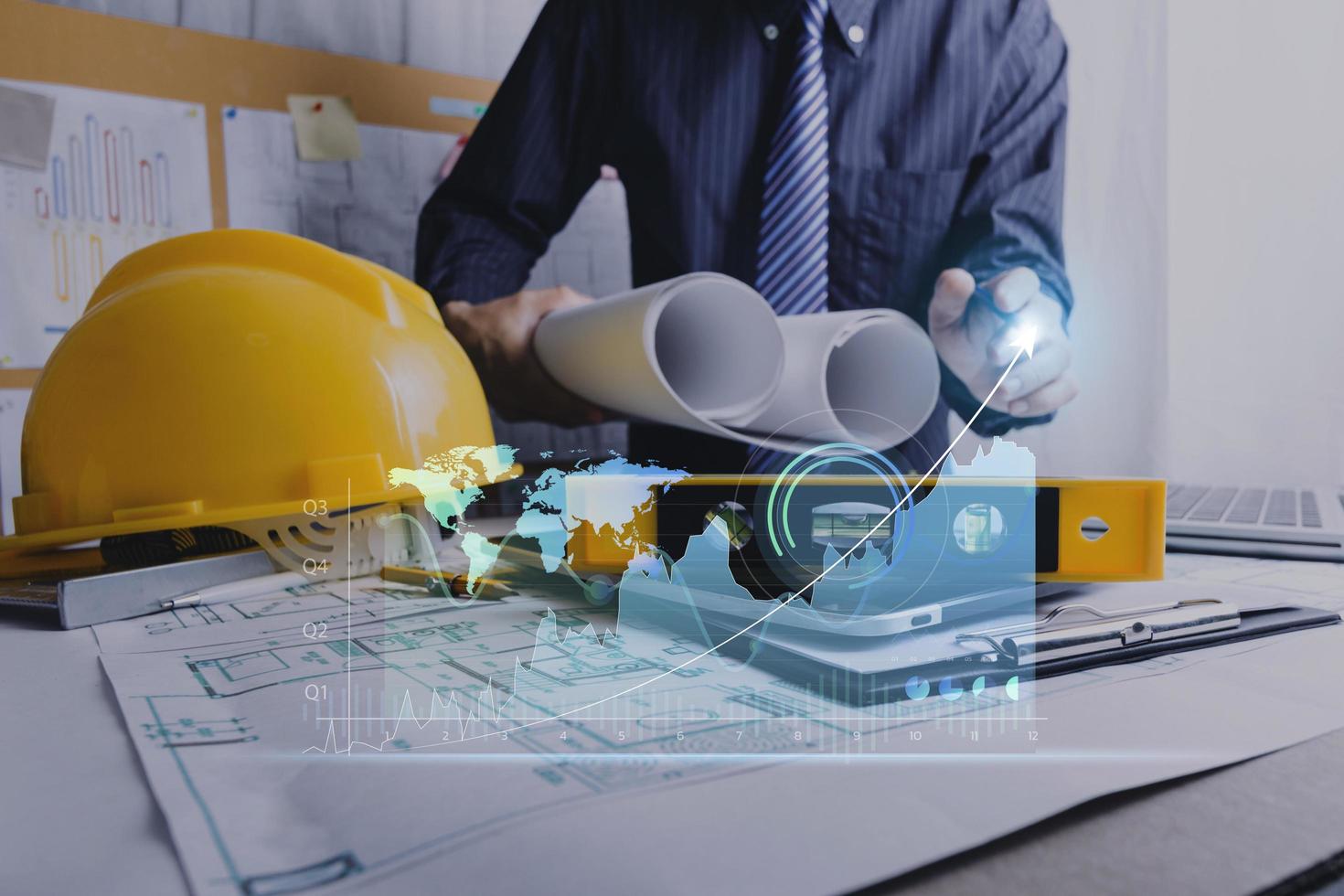 business hand working and laptop with on on architectural project at construction site at office desk in office photo