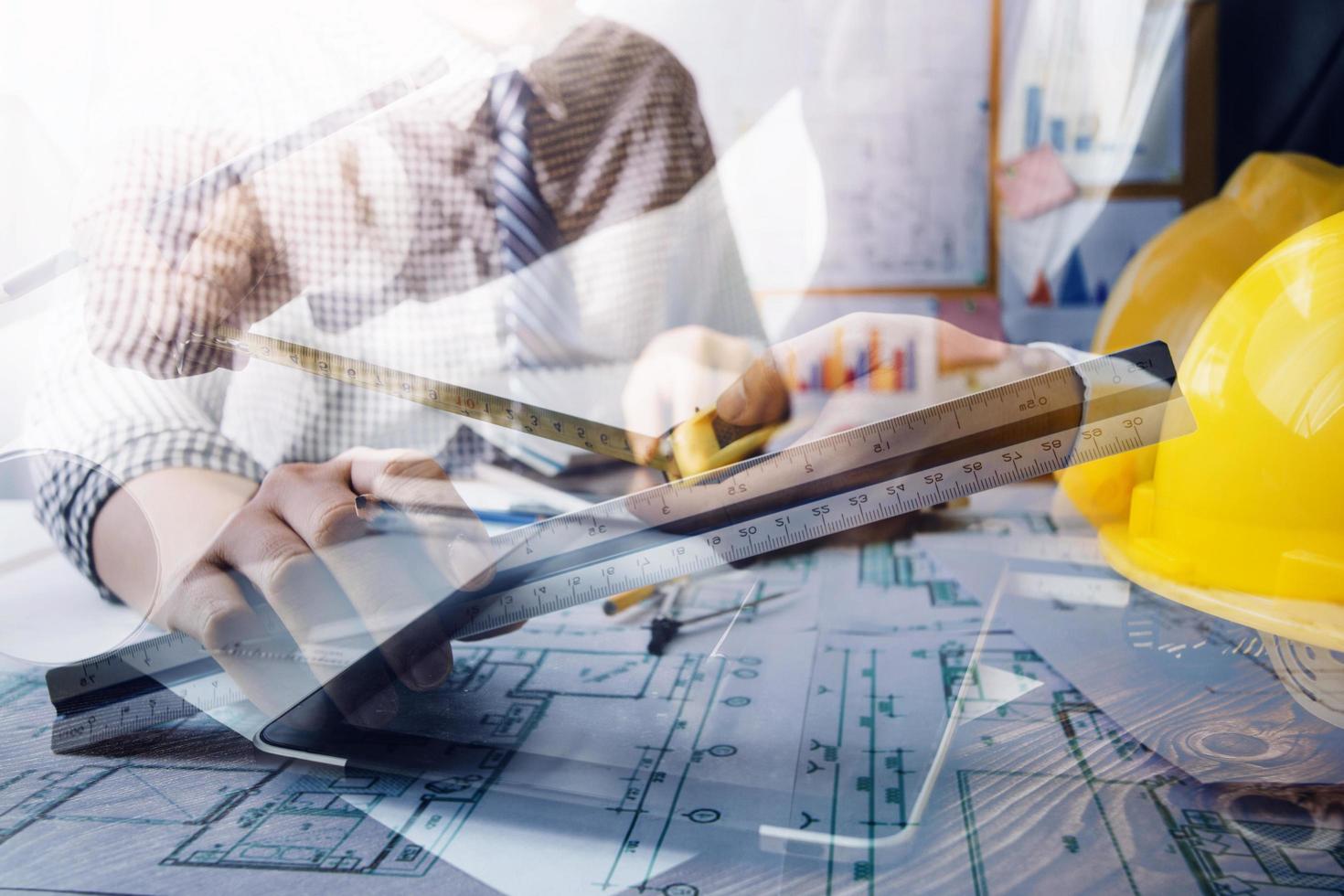 business hand working and laptop with on on architectural project at construction site at office desk in office photo