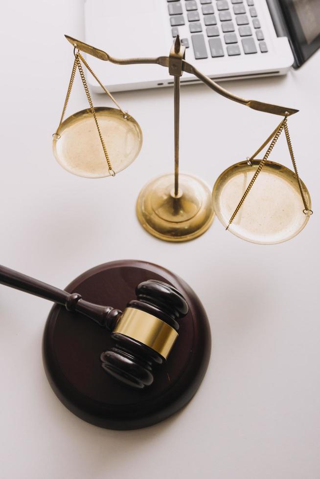 Business and lawyers discussing contract papers with brass scale on desk in office. Law, legal services, advice, justice and law concept picture with film grain effect photo
