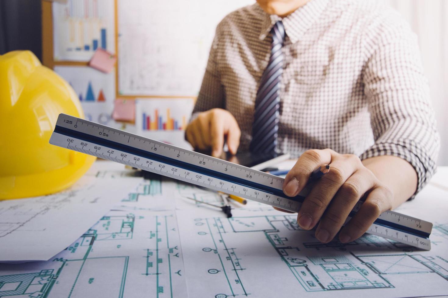 business hand working and laptop with on on architectural project at construction site at office desk in office photo