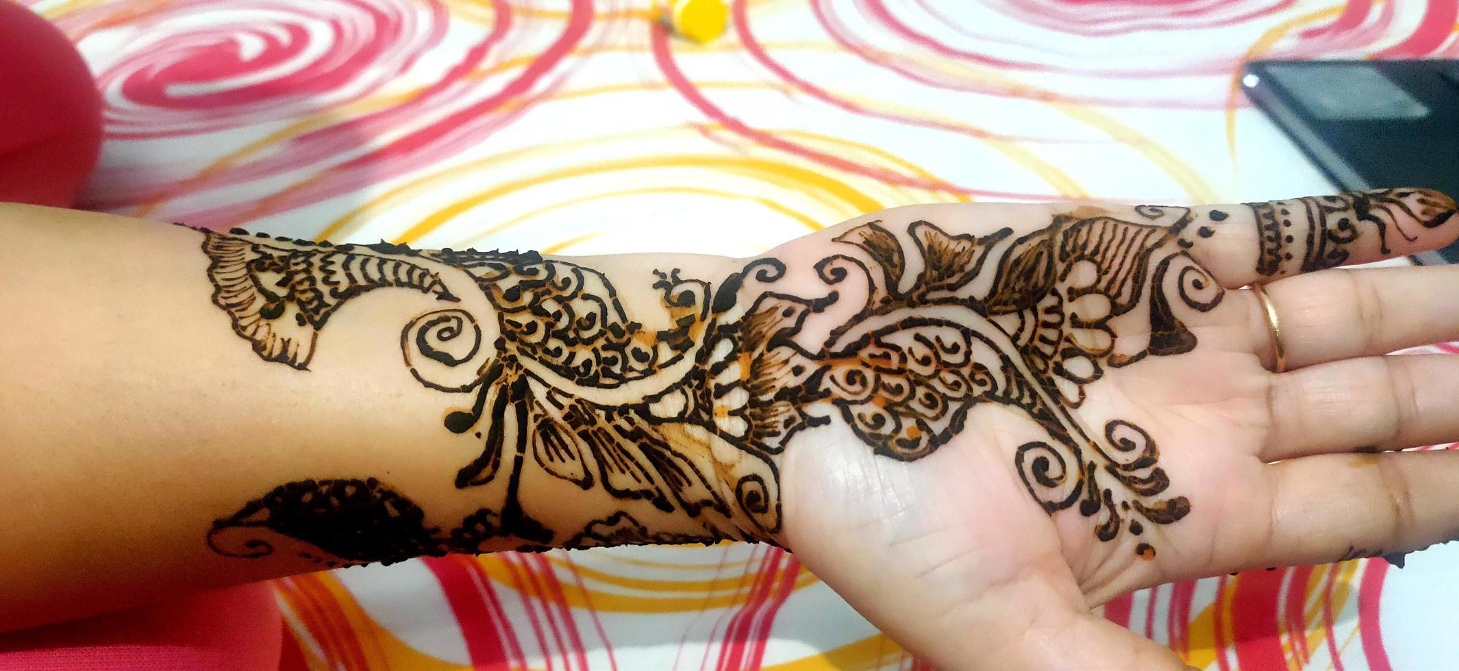 Carefully painted intricate design using henna, Mehndi art, on the hand of young Indian woman before an Indian Wedding photo