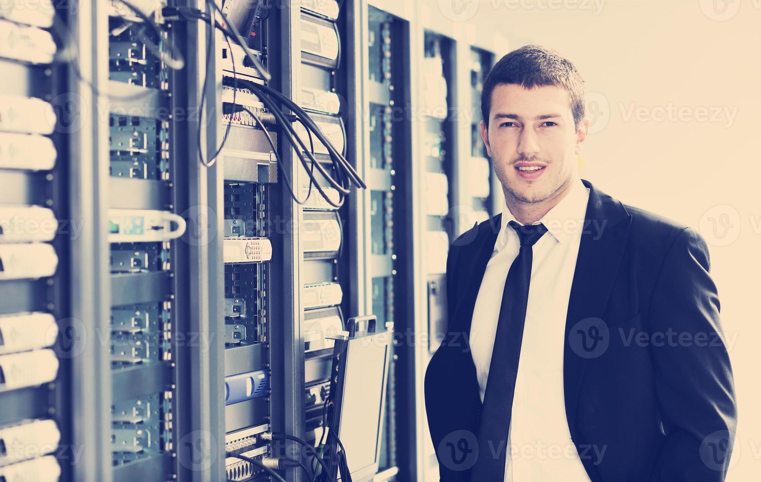 businessman with laptop in network server room photo