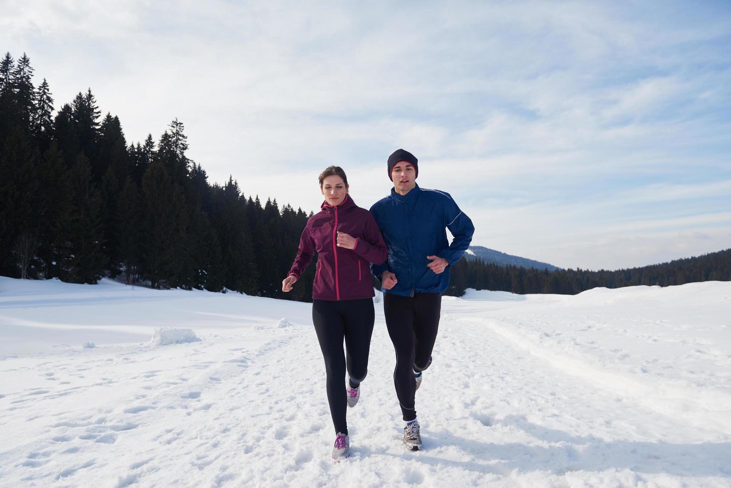 pareja trotando afuera en la nieve foto