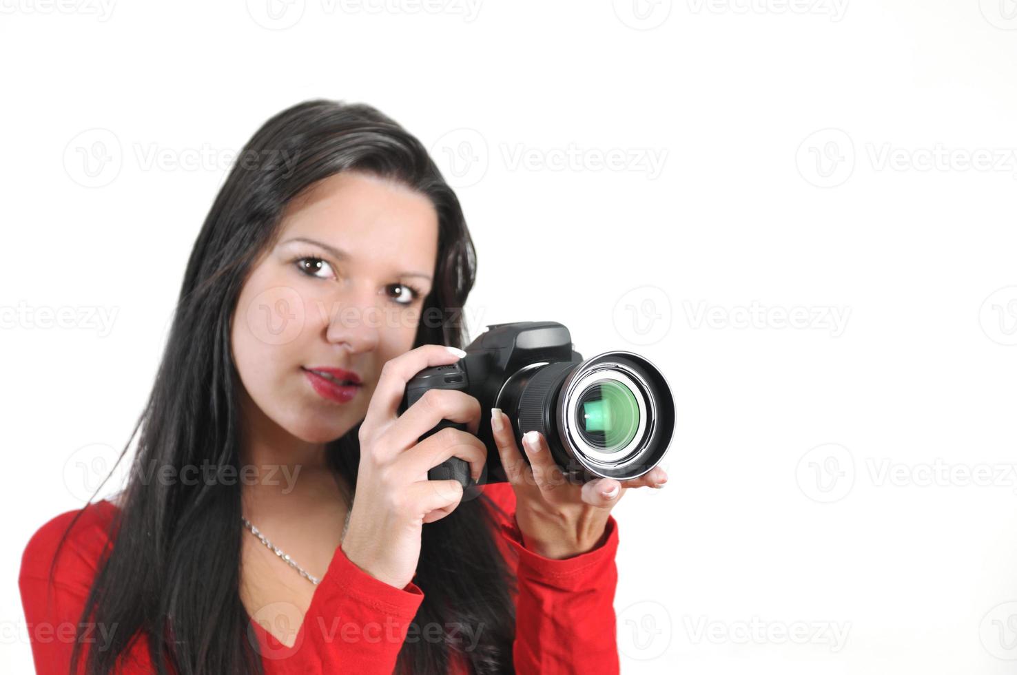 mujer joven sosteniendo una cámara en la mano tomando una foto aislada