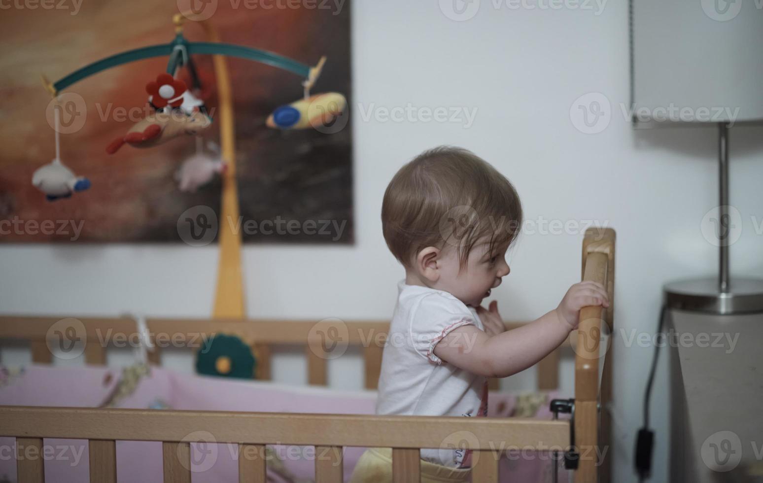 cute  little one year old baby and making first steps in bed photo