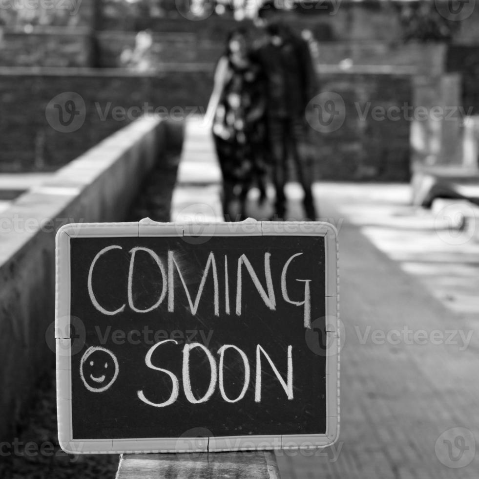 pareja india posando para una sesión de fotos de maternidad. la pareja está posando en un césped con hierba verde y la mujer está faluntando su panza en el jardín de lodhi en nueva delhi, india - blanco y negro